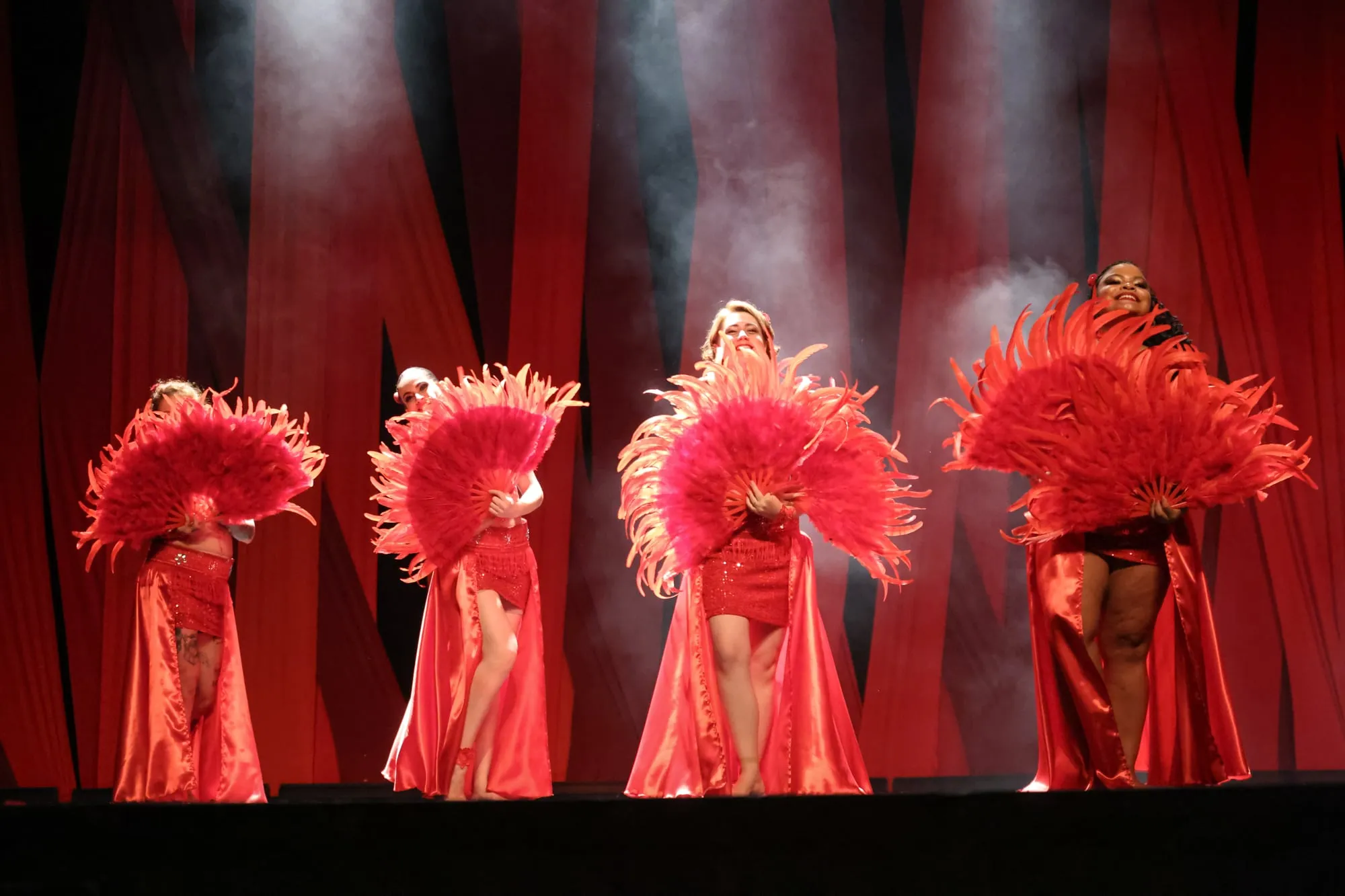 Bailarinas com leques de plumas vermelhas