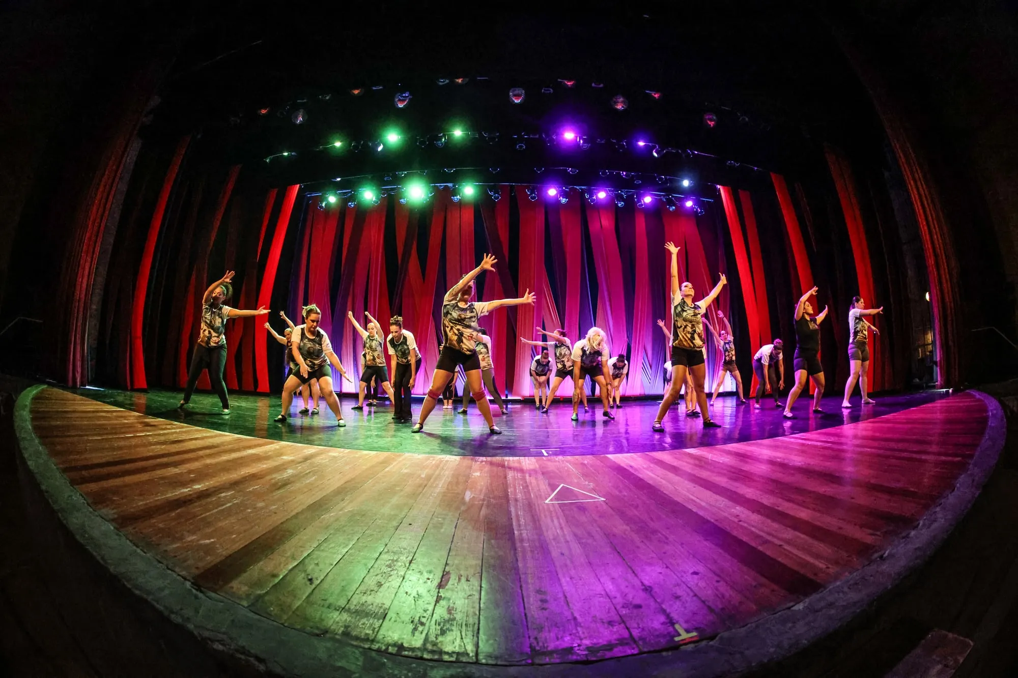 Turma dançando no palco com luzes coloridas