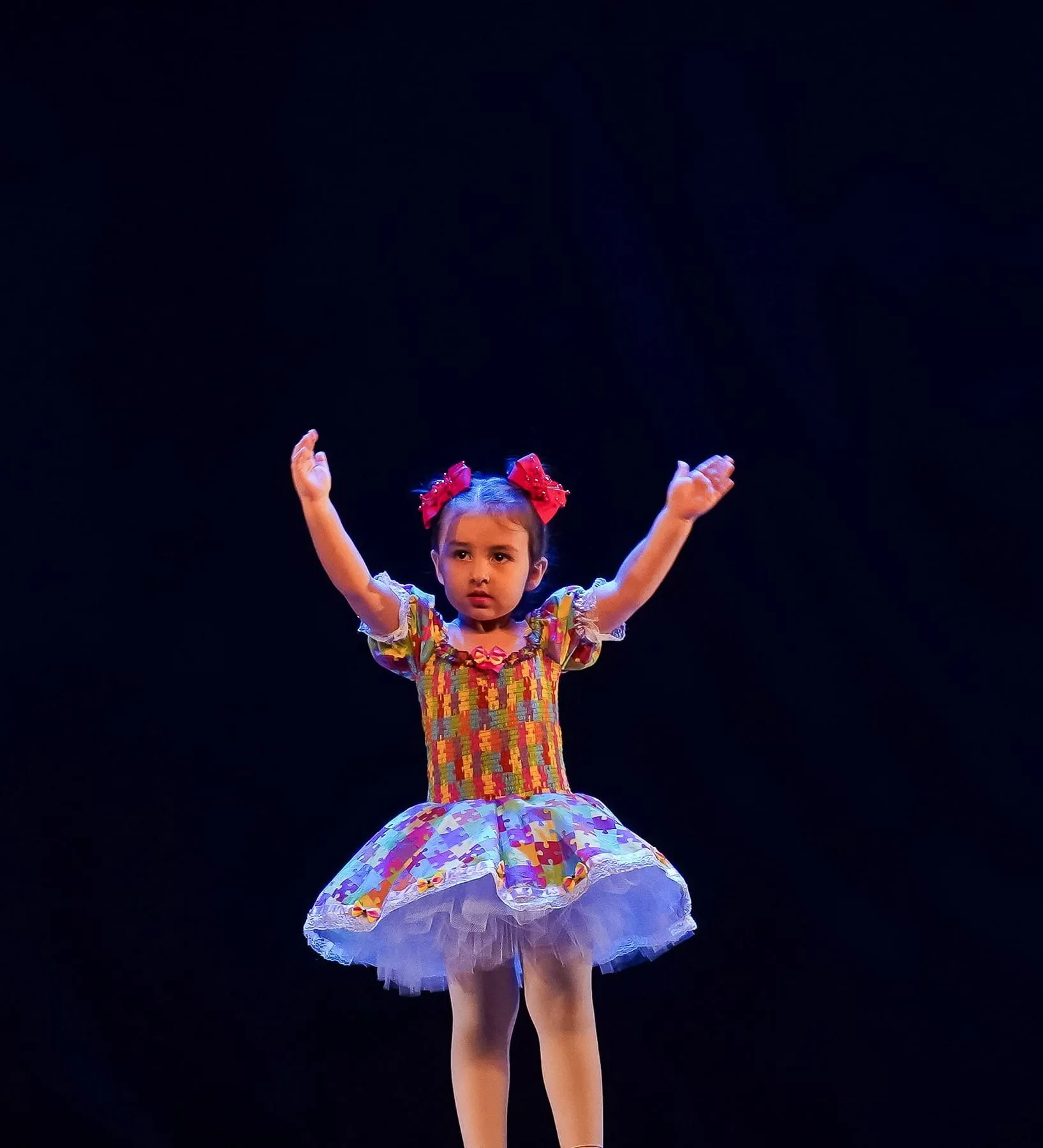 Pequena bailarina sozinha no palco azul