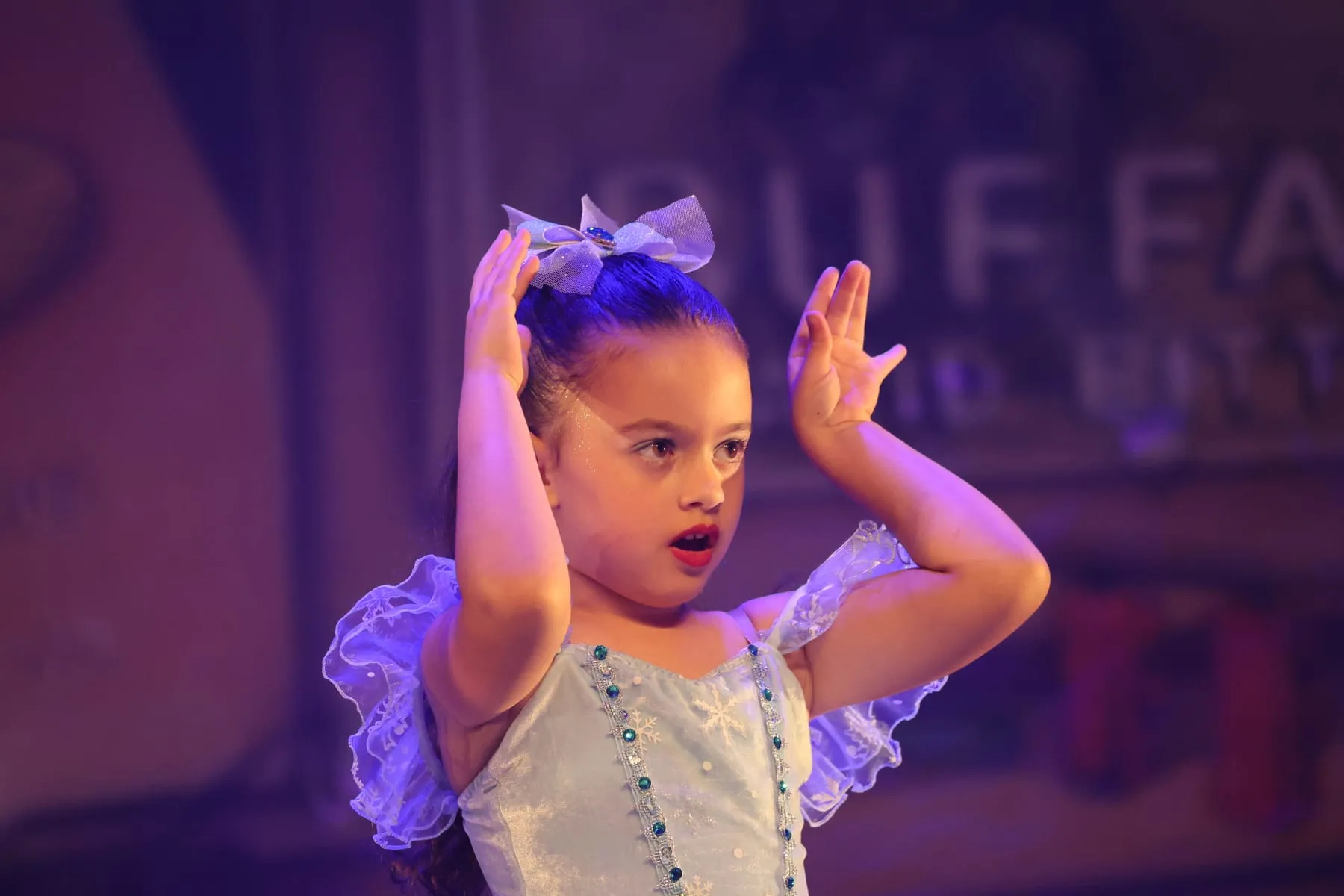 Pequena bailarina de laço azul no palco