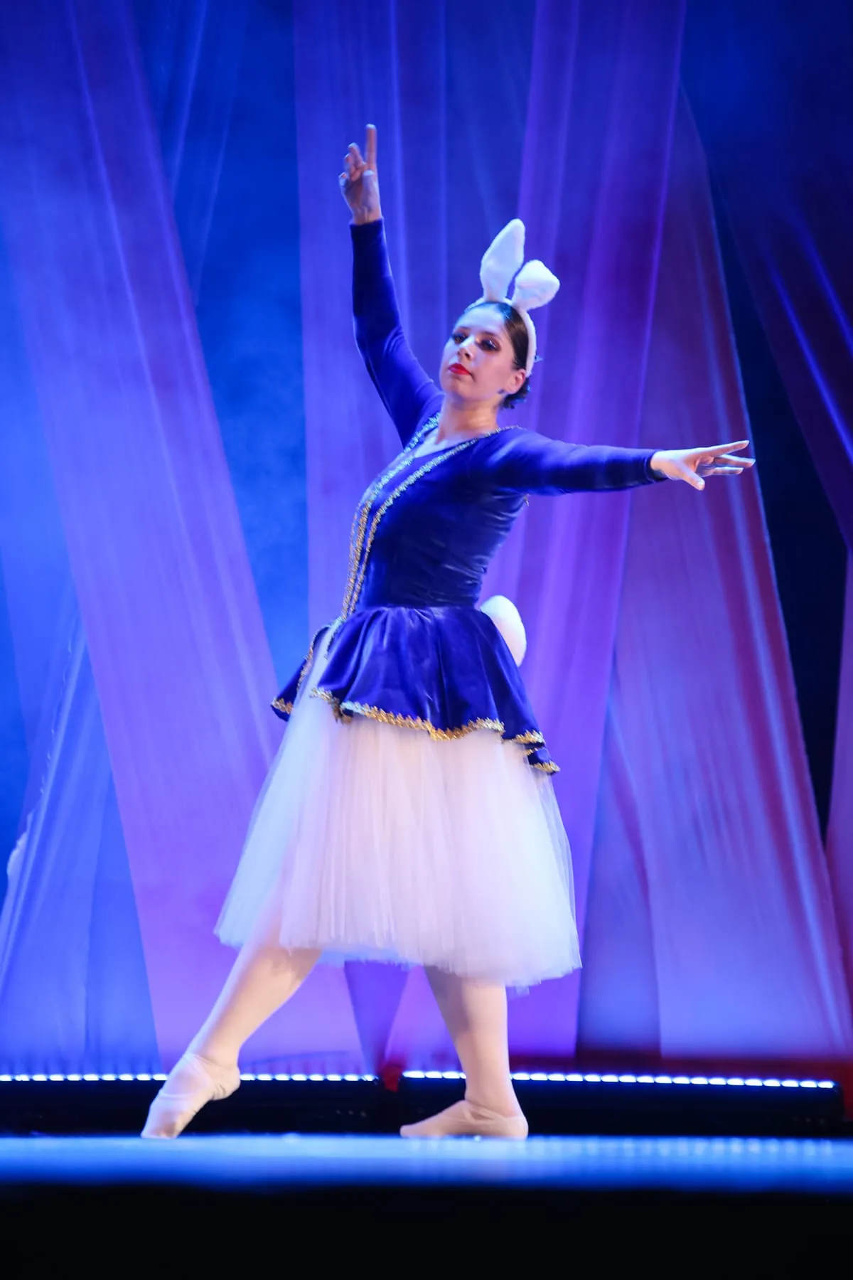 Bailarina de figurino azul e tule branco em cena